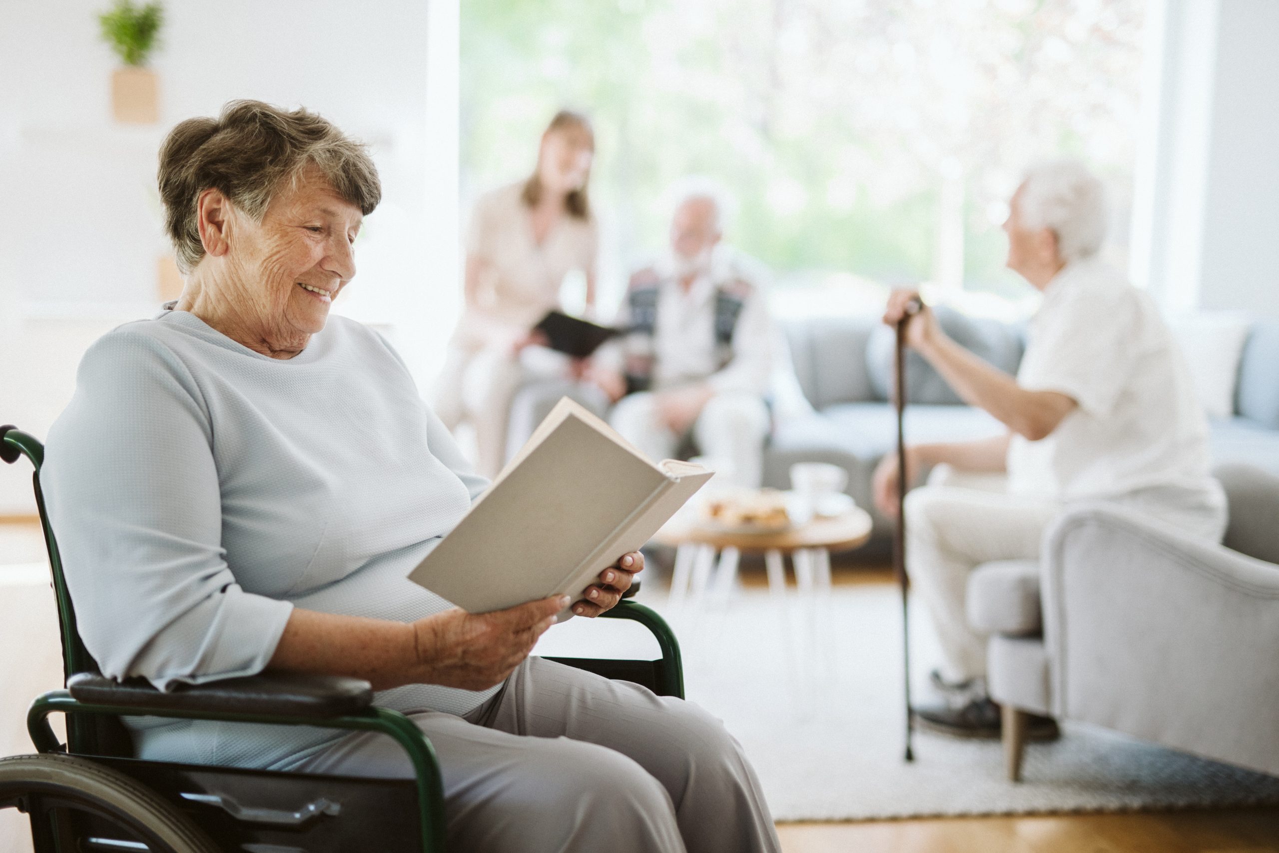 Happy disabled woman reading a book in the nursing home